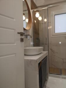 y baño con lavabo blanco y espejo. en Athenian Luxury apartment, near metro station Chalandri, Nu 1, en Atenas