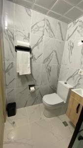 a bathroom with a toilet and a marble wall at Pilot hotel in Arnavutköy +7 photos