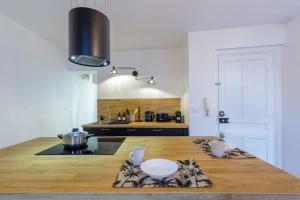 cocina con mesa de madera y encimera en La Maison 44 - T2 - central, terrasse, garage, en Montélimar