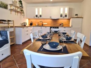 eine Küche mit einem Holztisch mit weißen Stühlen und einem Esszimmer in der Unterkunft Familientraum auf 120 m2 in Rostock in Rostock