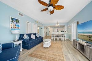 a living room with a blue couch and a ceiling fan at Luxury 20th Floor 2 BR Condo Direct Oceanfront Wyndham Ocean Walk Resort Daytona Beach | 2020 in Daytona Beach