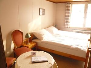 海登公园旅馆的一间卧室，里面有一张床、一张桌子和一把椅子