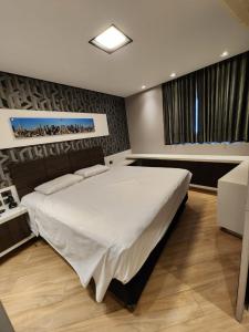 - une chambre avec un grand lit blanc dans l'établissement Studio no Hotel Bristol 500 - Bairro Batel, à Curitiba