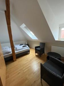een zolderkamer met een bed en een stoel bij MWMGästehaus Doppelzimmer 17 in Meine
