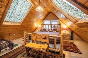 Bear Creek Lodge and Cabins in Helen Ga - Pet Friendly, River On Property, Walking Distance to downtown Helen في هيلين: غرفة نوم بسرير في كابينة خشبية