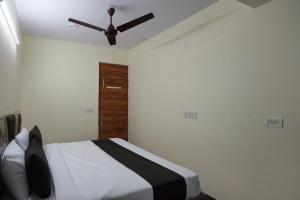 a bedroom with a bed with a ceiling fan at Super Collection O Hotel SPS in Ghaziabad
