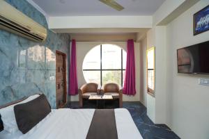 a hotel room with a bed and a window at Super Collection O Hotel SPS in Ghaziabad