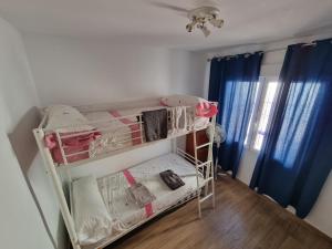 Habitación pequeña con litera y ropa en Casa Tranquila cerca del Mar en Santiago de la Ribera