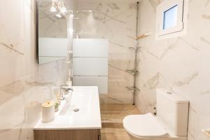 a white bathroom with a sink and a toilet at Poepoe Home Trikala in Tríkala