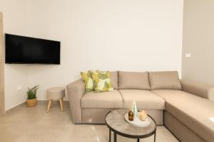 a living room with a couch and a flat screen tv at Poepoe Home Trikala in Tríkala
