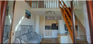 a living room with a staircase and a kitchen at Hameau du Rivage 224 - Rez de jardin climatisé - 3 étoiles - 6 Pers - Jardin - Piscine - Vélos prêtés - Parking - 400m de la plage de La Lagune - WIFI in Saint-Cyprien