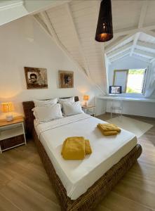 a bedroom with a large bed with yellow towels on it at Villa Tilanga in Saint-François