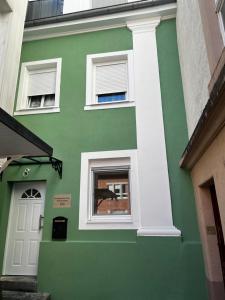 um edifício verde com uma janela e uma porta em Kurstadtapartment Baden-Baden em Baden-Baden