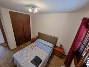 Habitación pequeña con cama y puerta en Casa Tranquila cerca del Mar, en Santiago de la Ribera