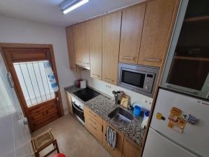 eine kleine Küche mit Spüle und Kühlschrank in der Unterkunft Casa Tranquila cerca del Mar in Santiago de la Ribera