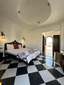 a bedroom with a bed and a checkered floor at El Salam hotel in Dahab