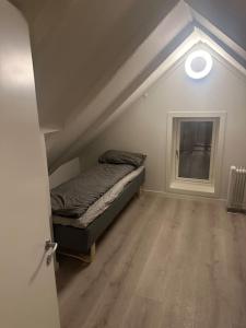 een slaapkamer met een bed en een raam bij I hjertet av Nordens Paris. in Tromsø