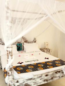 a bed with a white canopy with stars on it at Lalasalama B&B in Watamu