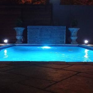 a swimming pool at night with lights in it at The Royal Prime Guest Lodge in Centurion