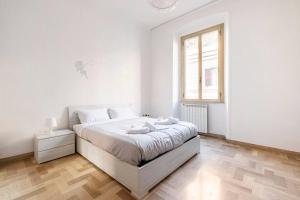 een witte slaapkamer met een groot bed en een raam bij Casa amoR in Trastevere in Rome