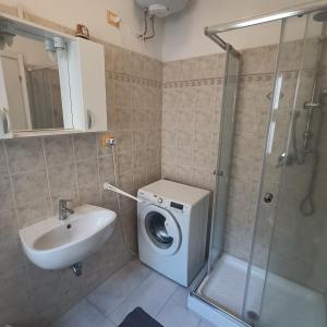 a bathroom with a washing machine and a sink at Appartamento vista mare Tarquinia in Tarquinia