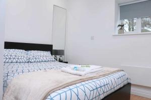 a white bedroom with a bed with a black headboard at Suffolk Cosy Corner with free parking, 10min walking to town centre in Bury Saint Edmunds
