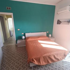 a bedroom with a bed and a blue wall at Appartamento vista mare Tarquinia in Tarquinia