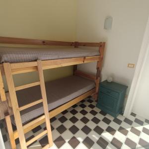 a bunk bed in a room with a checkered floor at Appartamento vista mare Tarquinia in Tarquinia