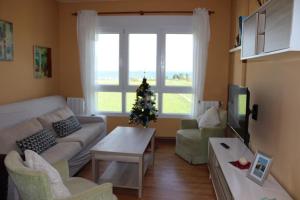 a living room with a christmas tree and a couch at Apartamento en playa de Foz in Foz