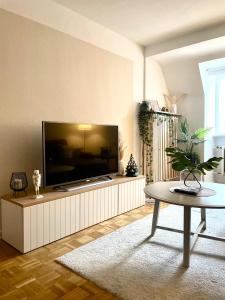 un soggiorno con una grande TV a schermo piatto di Urban Retreat - Central and Historic with Private Parking a Würzburg