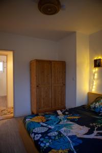 ストラスブールにあるAppartement Strasbourgのベッドルーム1室(ベッド1台付)、木製キャビネットが備わります。