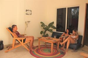 un grupo de personas sentadas en una sala de estar en Mi Puerto Beach Hostel en Puerto Escondido