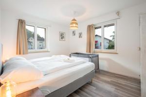 1 dormitorio con 1 cama grande y 2 ventanas en Moderne Wohnung mit Parkplatz - Top Floor, en Ostermundigen