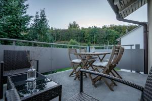 a patio with a table and chairs on a balcony at Moderne Wohnung mit Parkplatz - Top Floor in Ostermundigen