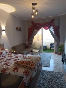 a bedroom with a bed and a couch and a window at منتجع فلورانزا 50 in Hurghada