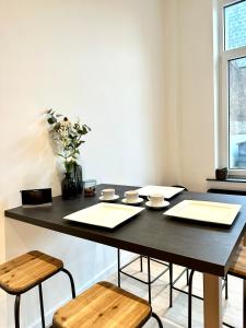 een zwarte tafel met twee stoelen en een vaas met bloemen bij Cozy Bed and Breakfast at European Commision in Brussel