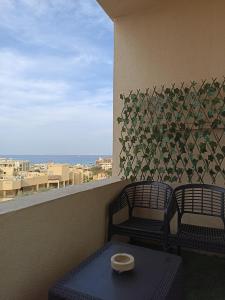 two chairs and a table on a balcony with a view at منتجع فلورانزا 50 in Hurghada