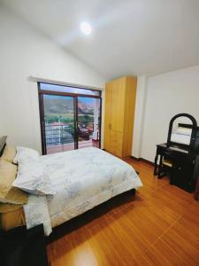 1 dormitorio con cama, escritorio y ventana en Hostería Quinta Esperanza - Alquiler del Alojamiento Entero en Loja