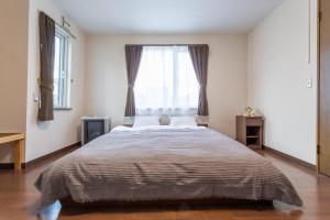 a bedroom with a large bed with a window at Kamonoya in Lake Toya