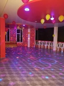 Hostería Quinta Esperanza - Alquiler del Alojamiento Entero في لوخا: غرفة مع صالة رقص مع كراسي وإضاءة أرجوانية