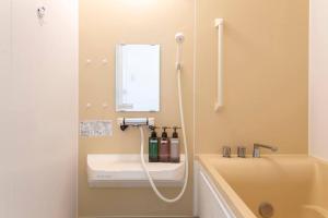 a bathroom with a sink and a mirror and a tub at Kamonoya Toya House in Lake Toya +65 photos