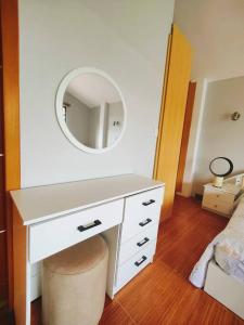 Un escritorio blanco con un espejo encima. en Hostería Quinta Esperanza - Alquiler del Alojamiento Entero, en Loja