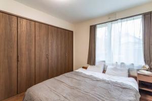 a bedroom with a bed and a large window at Kamonoya in Lake Toya