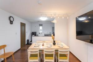 a dining room with a white table and chairs at Kamonoya Toya House in Lake Toya