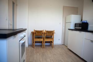 uma cozinha com uma mesa, uma cadeira e um frigorífico em Appartement Strasbourg em Estrasburgo