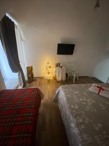 a bedroom with a christmas tree and a room with a bed at Al Vicolo di Ercolano in Ercolano