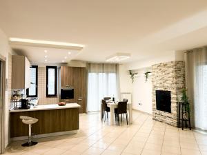 a kitchen and living room with a table and a fireplace at Kiro Apartment Experience Pompei in Angri