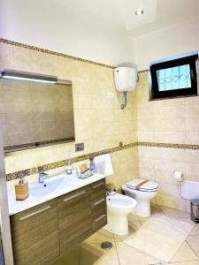 Un baño con lavabo, inodoro y espejo. en Kiro Apartment Experience Pompei, en Angri 14 fotos más