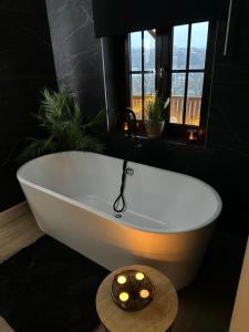a white bath tub in a bathroom with windows at Suite Tino in Verviers