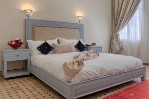 a bedroom with a large bed with white sheets and pillows at Palais du Calife Riad Spa & Clubbing in Tangier